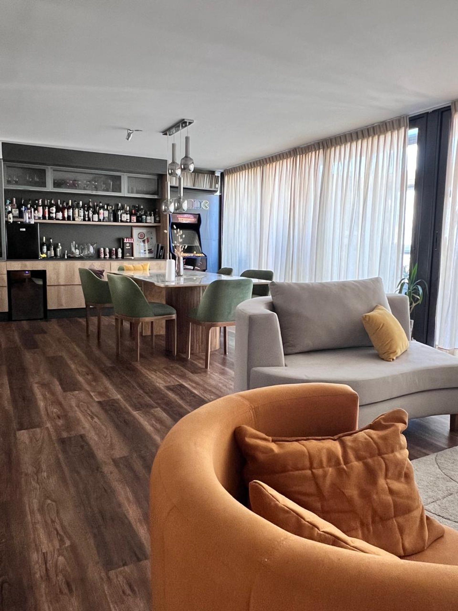 Sala de estar moderna com sofá curvo laranja e jantar — projeto Proyecto 60, por Momas Interiores, em La Plata
